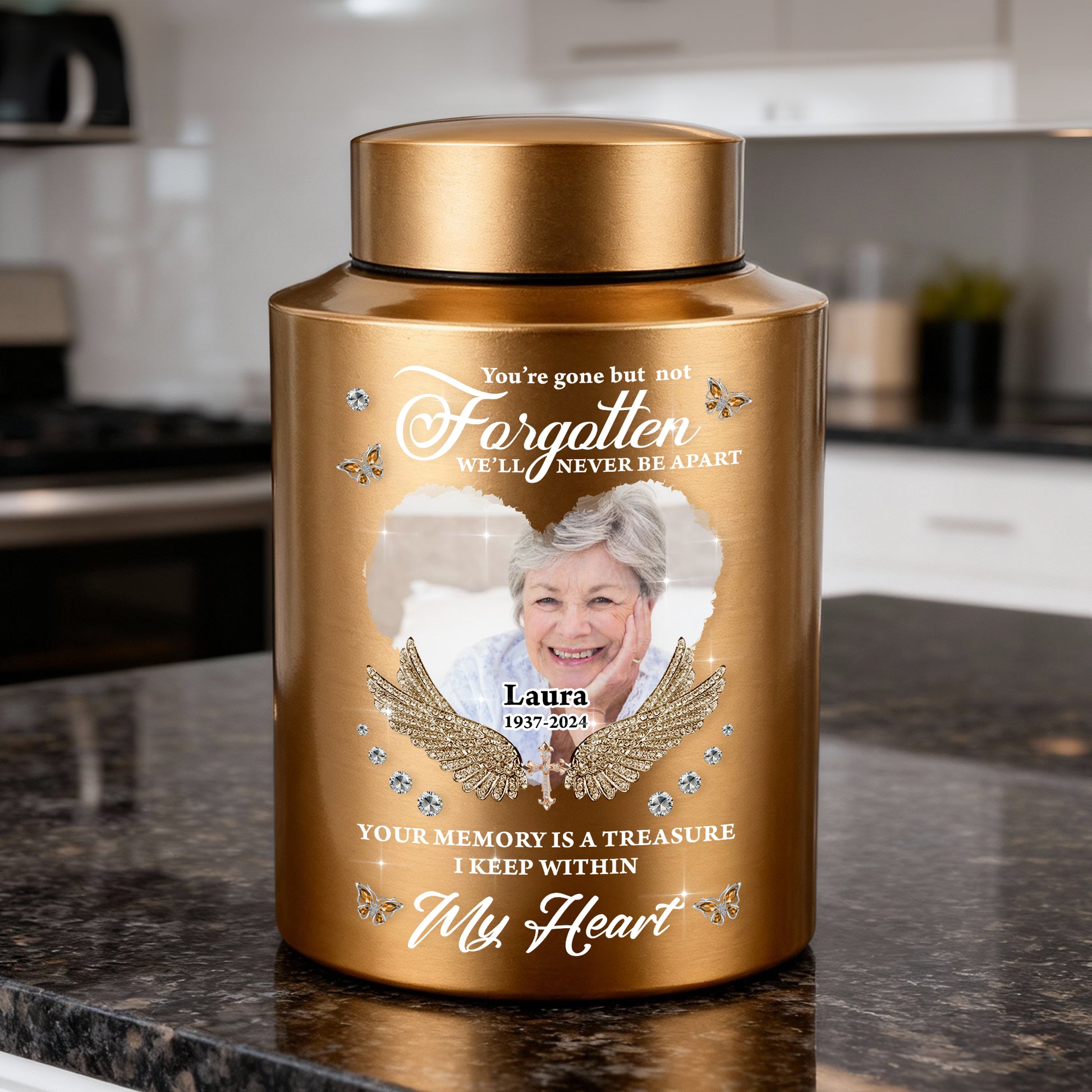 Stainless steel keepsake urn for ashes with "In Loving Memories" engraving, displayed on a dark surface.