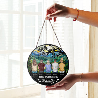 Personalized family photo stained glass suncatcher hanging in a window.